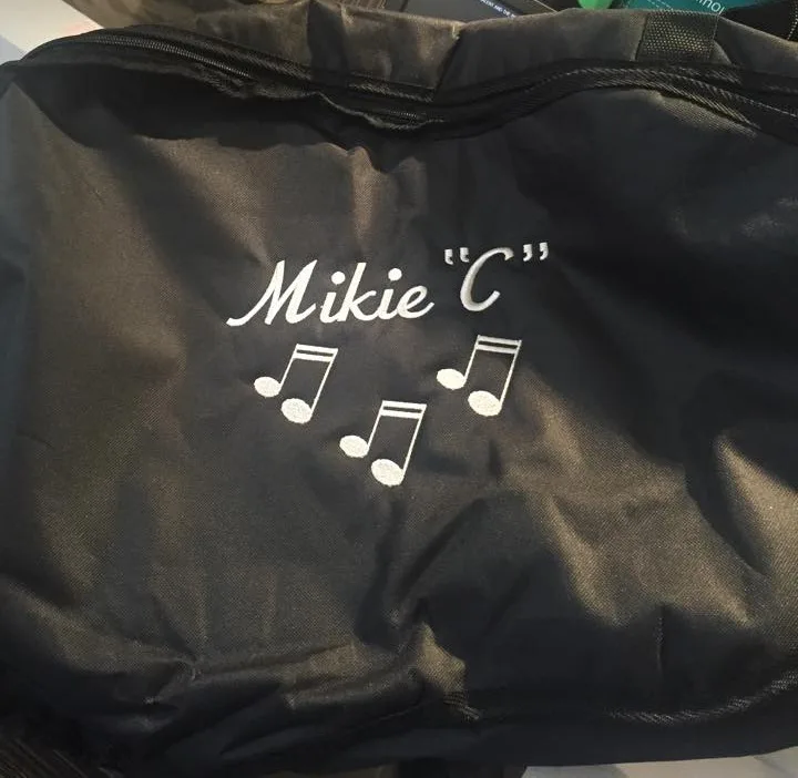 Embroidered name and music notes on a black bag